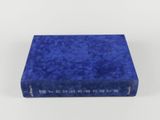 un livre bleu posé sur une surface blanche