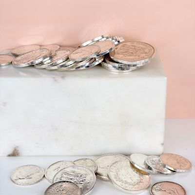 a pile of coins sitting on top of a marble block