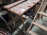several pieces of wood sit on top of a table next to a ladder