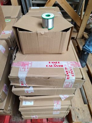 a stack of boxes and a spool of thread on a pallet