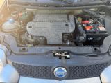 le moteur d'une voiture dont le capot est ouvert et qui contient une batterie de voiture