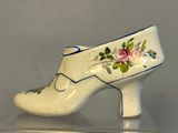 a white shoe with blue trim and flowers on it