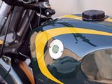 a green and yellow motorcycle parked on the side of the street