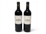 two bottles of red wine sitting next to each other on a white surface