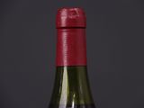bottle of wine with a red cap on a black background