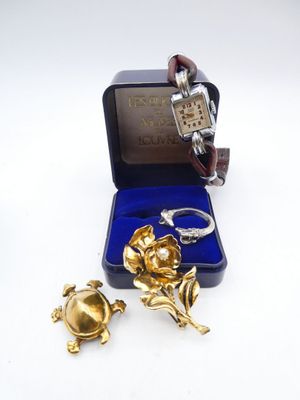 two pieces of jewelry are sitting in a box on a white surface