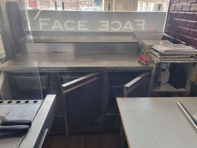 une photo de la cuisine d'un restaurant avec une grande enseigne accrochée au mur