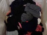 a white bag full of clothes on a bed