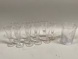 six verres et un verre à shot posés sur une surface blanche