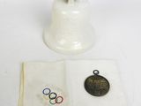 a white bell with a medal on it next to a napkin