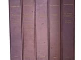 quatre livres sont alignés sur une surface blanche