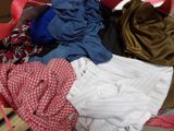 a pile of clothes sitting in a basket on the floor