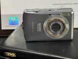 un appareil photo argenté posé sur une valise