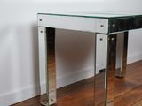 an image of a glass and chrome console table on a hard wood floor