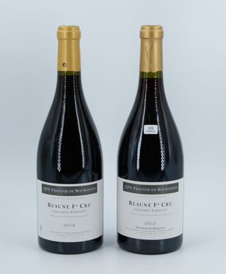 two bottles of wine sitting next to each other on a white surface