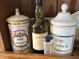 a wooden shelf with a bottle of wine, a canister, and a pair of scissors