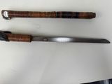 two knives are on a table with a white surface