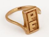 un gros plan d'une bague en or sur laquelle figure la lettre « e »