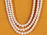 un gros plan d'un collier de perles sur fond jaune