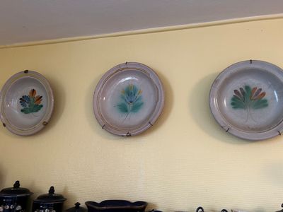 trois assiettes accrochées au mur au-dessus d'une cuisinière
