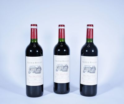 trois bouteilles de vin rouge posées sur une table blanche