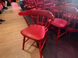 de nombreuses chaises rouges alignées en rang dans un restaurant