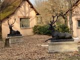 deux statues représentant un cerf et un cerf couché au sol