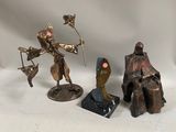 three bronze figurines of a man and a woman sitting on a bench