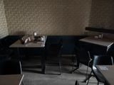 tables and chairs in a restaurant with a wallpapered wall behind them