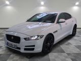 the white jaguar car is parked on a checkered floor