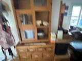 a blurry photo of a living room with a chair and a bookcase