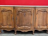 une armoire en bois avec un plateau en marbre, posée sur un sol carrelé