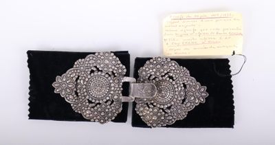 Gros plan sur une ceinture noire avec une boucle en argent.