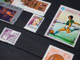 many stamps on the table with a picture of a man kicking a soccer ball