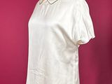 a white shirt on a mannequin stand against a red background