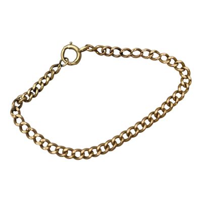 gros plan d'un bracelet en chaîne en or sur fond blanc
