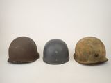 three helmets are lined up in a row on a white surface