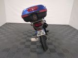 a blue and red motorcycle parked on a black and white checkered floor