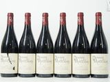 six bouteilles de vin sont alignées sur une table