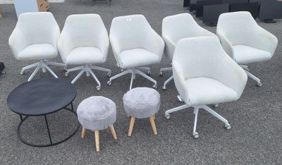 Plusieurs chaises et tabourets sont disposés en cercle sur le sol.