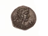 une vieille pièce de monnaie sur laquelle figure le visage d'une femme, sur un fond blanc