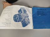 a manual for a camera on a table next to a cell phone