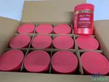 une boîte en carton remplie de bocaux roses et d'une bouteille de liquide