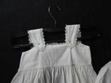 a white dress hanging on a hanger on a black background