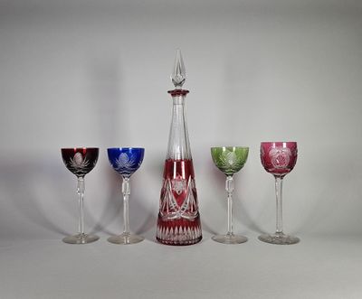 quatre verres à vin et une carafe posés sur une table