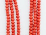 un collier de perles rouges muni d'un fermoir en or