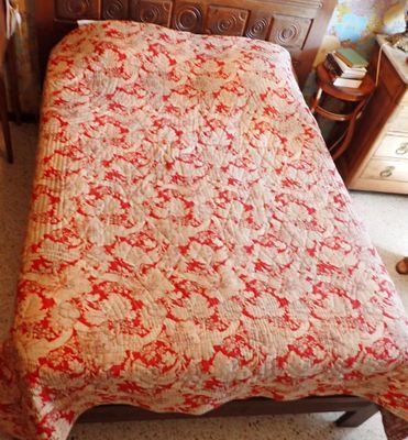 un lit recouvert d'une couette rouge et blanche