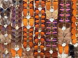 many different colored butterflies on display in a display case