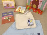 le premier livre d'un bébé, un livre, un bavoir et un livre-bavoir posés sur un canapé