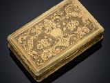 a gold - plated cigarette case with a design of flowers and leaves